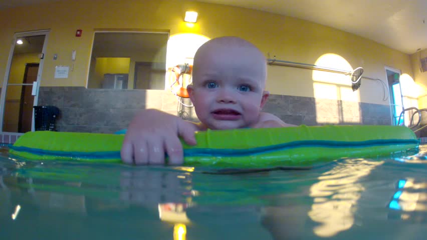 Underwater shot of a cute little baby boy at the swimming pool with his family.