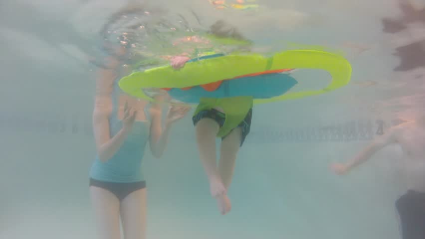 Underwater shot of a cute little baby boy at the swimming pool with his family.