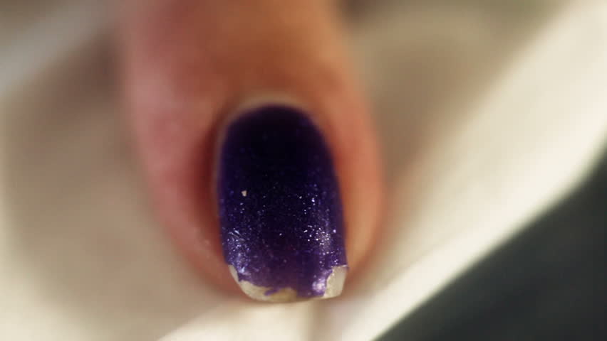 Woman removing the gel like nail polish, after it was soften by gel remover