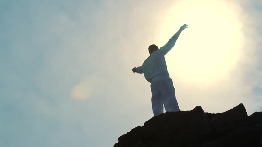 Worship Pose Silhouette of Man on Mountain Peak Raising Religious Arms at Sun