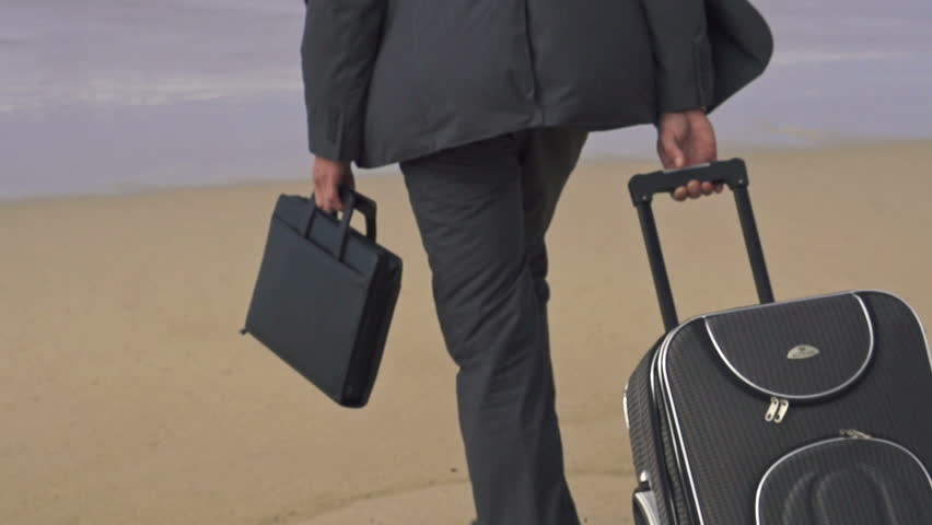 Businessman with suitcase walking on beach, super slow motion, shot at 240fps
