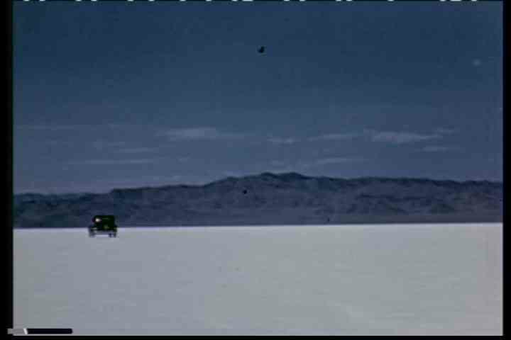 1930s - A car drives along a road near Salt lake City, Utah in the 1930' and across the salt flats.