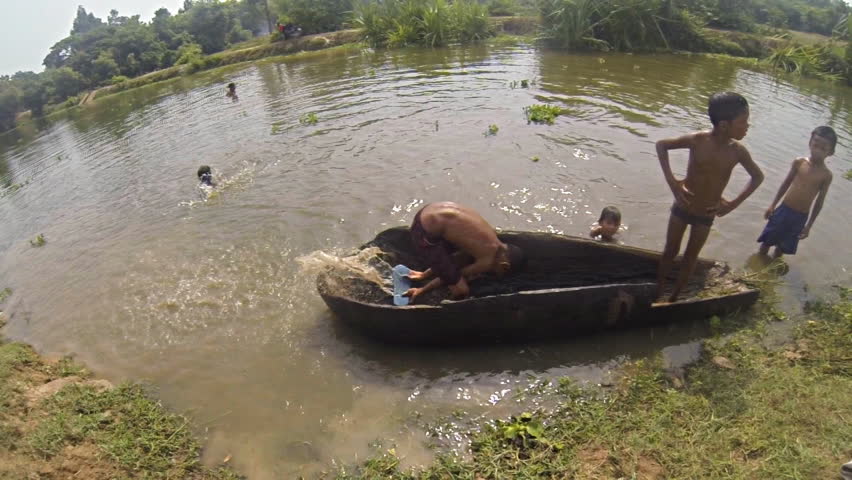 SIEM REAP, CAMBODIA - MAY 17: Cambodian kids playing in the water close to Angkor Thom  in Siem Reap Cambodia on May 17th 2013. Recorded at slow motion 120fps