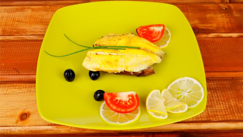 grilled fish fillet served over wood with tomatoes olives and bread 1920x1080 intro motion slow hidef hd