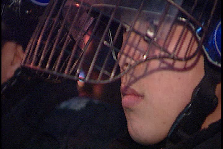 SEOUL - MARCH 02, 2003: Night time peaceful anti-war demonstration in Jung-gu; CU policeman in helmet and riot gear.