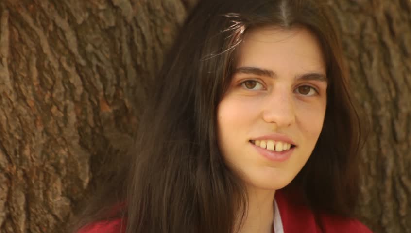Outdoor portrait of happy brunette young adult woman.
