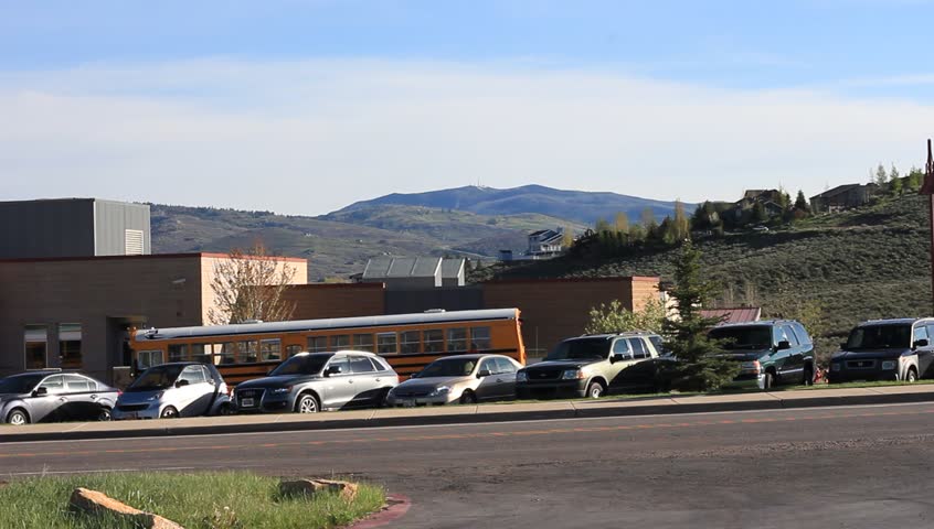 School bus passes by in front of an elementary school.