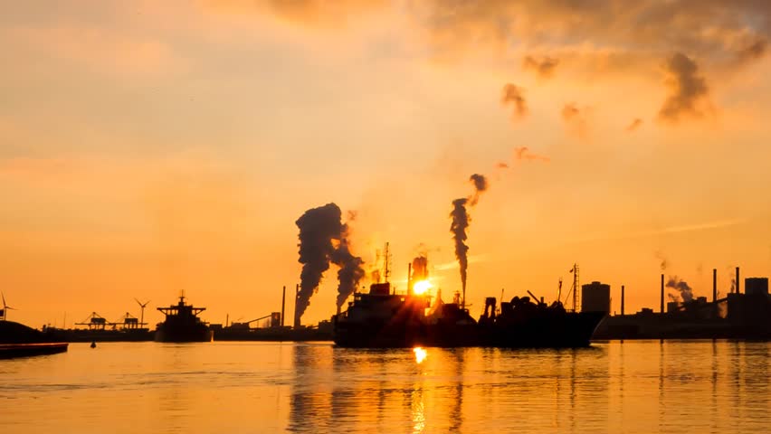 Beautiful full HD time lapse of heavy industry with smoking chimneys and cargo ships along a waterway in IJmuiden, the Netherlands. 