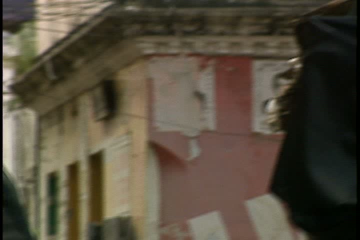 MOMBASA, KENYA, AFRICA - DECEMBER 01, 1998: Street scenes in Mombasa; CU woman dressed head to toe in black niqab walking towards camera. Camera pans left to another woman in black.