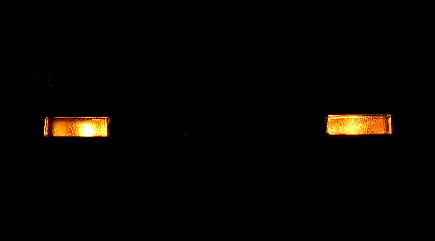 LED lights of a DSL modem in a dark room with the ethernet light blinking.