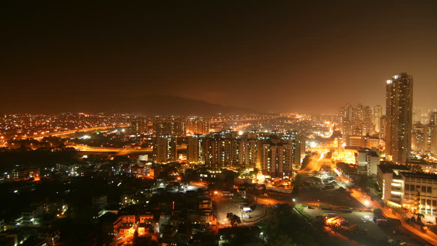 Hong Kong Cityscape Timelapse. Sunset of Yuen Long. Wide shot of Yuen Long, Hong Kong. A skyscraper at the right facing the low-rise buildings and houses surrounded by hills and main traffic highway. 