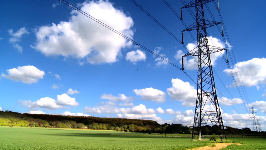 Time-lapse clouds & blue sky behind electricity pylon