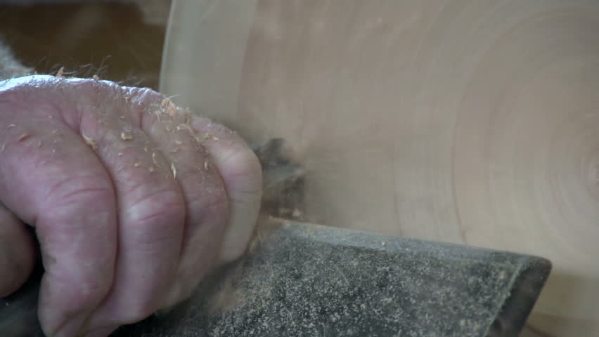 Dargaville, New Zealand. May 2013. Close up of wood carver using a skew chisel creating a timber bowl from the wood of a swamp kauri tree.