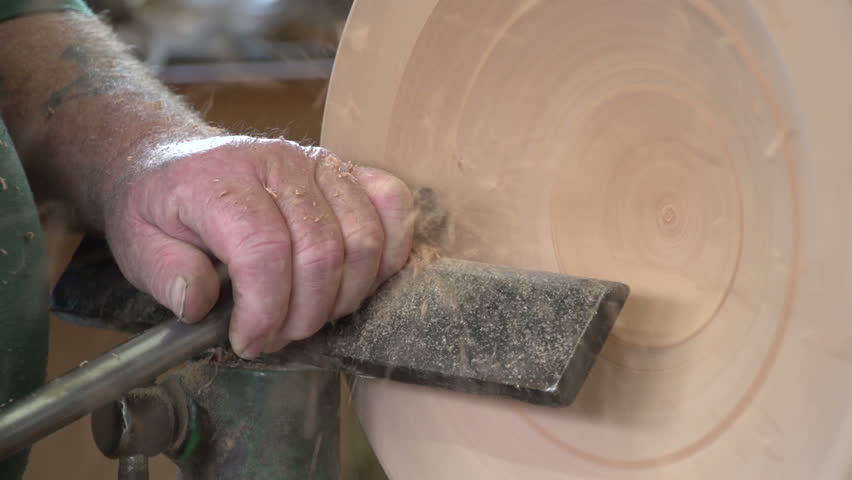 Dargaville, New Zealand. May 2013. Close up of wood carver using a skew chisel creating a timber bowl from the wood of a swamp kauri tree.