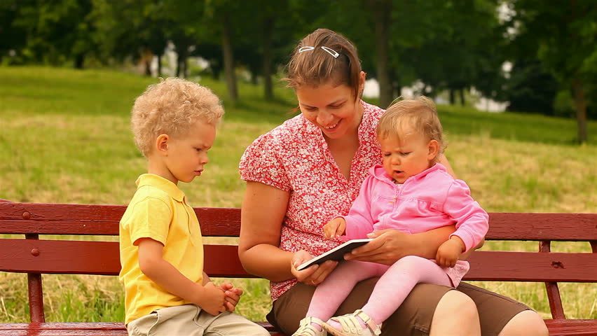 mother and two children, reading and watching Tablet Computers