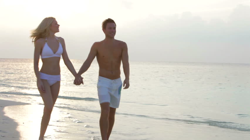 Romantic Couple Walking On Beautiful Tropical Beach 
