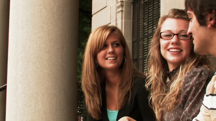 Students meet outside the library on a college campus.