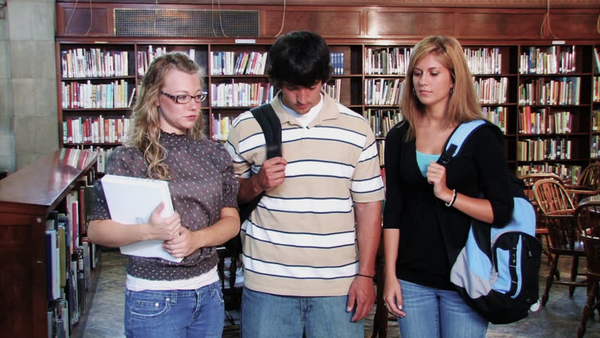 A confident group of students proudly look at the camera and smiles.