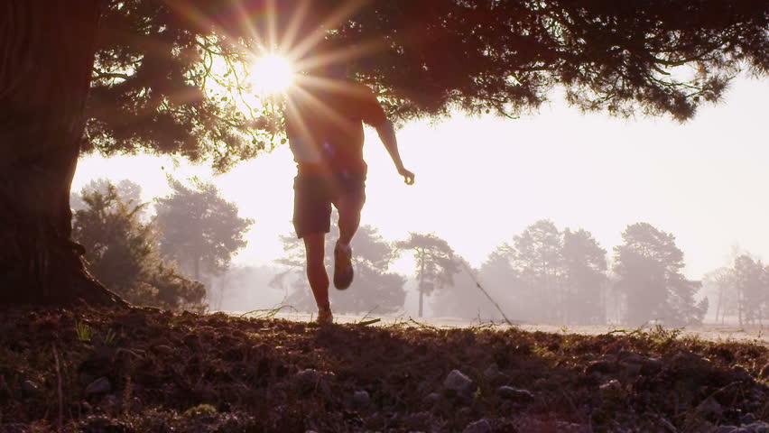 Jogger running through park, slow motion