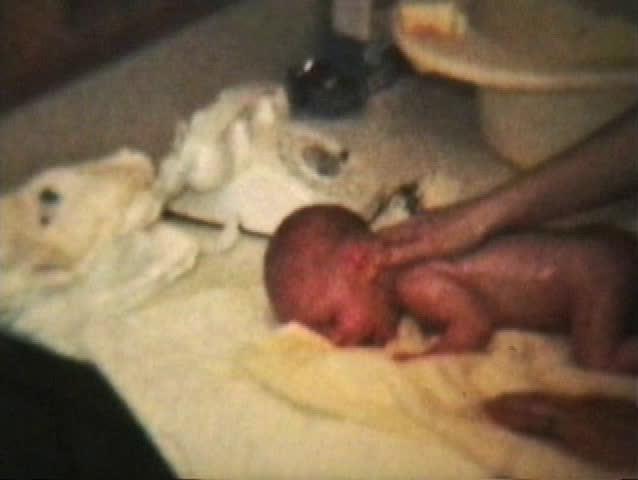 Clip of a newborn baby getting a rub down after a bath. (1964 - Vintage 8mm film footage)