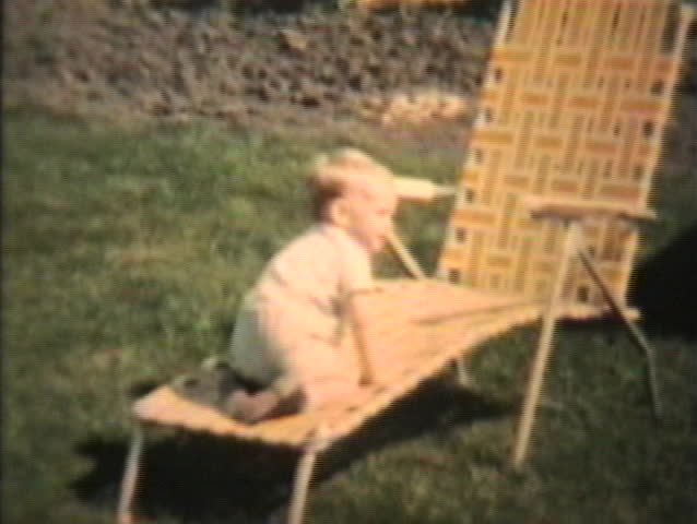 A Toddler Plays With Garden Hose In The Backyard. 1963 (Vintage 8mm film footage)