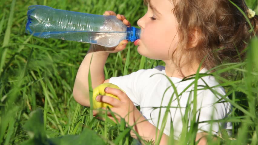 girl drinking water from  bottle and eating apple 