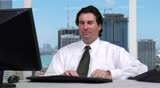 Young businessman taking a phone call - office shot overseeing the city skyline