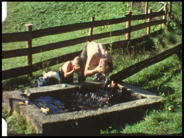 Father and son washing outdoors (vintage 8 mm amateur film)