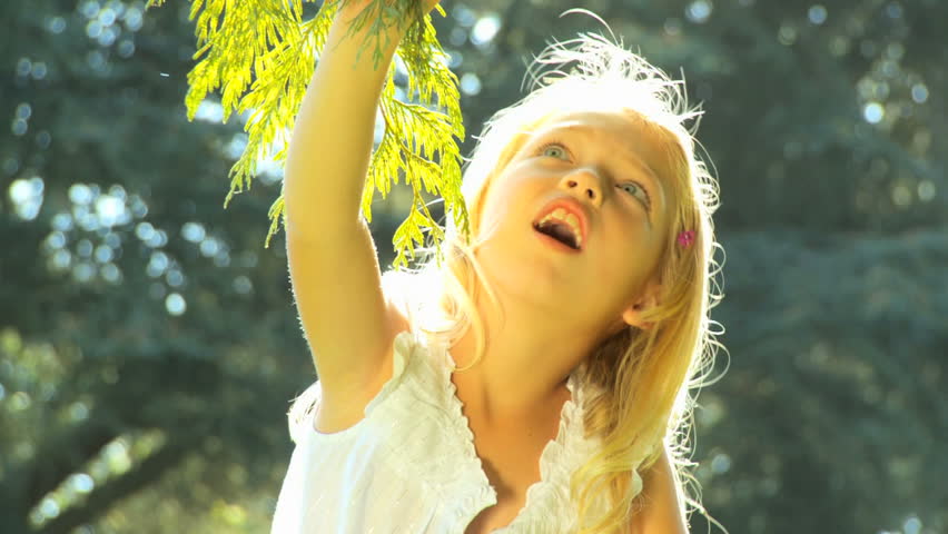 Young father holding his daughter on his shoulders while outdoors on a summers day