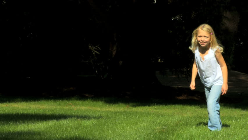 Pretty little blonde girl having fun outdoors on a summers day