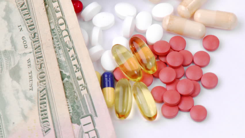 Dollars and colourful pills turning against white background