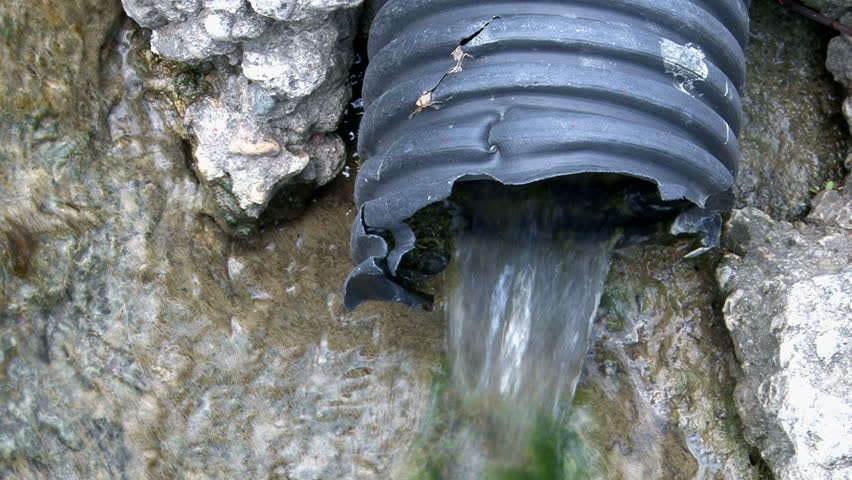 Plastic Hose Draining Water out of Rocks