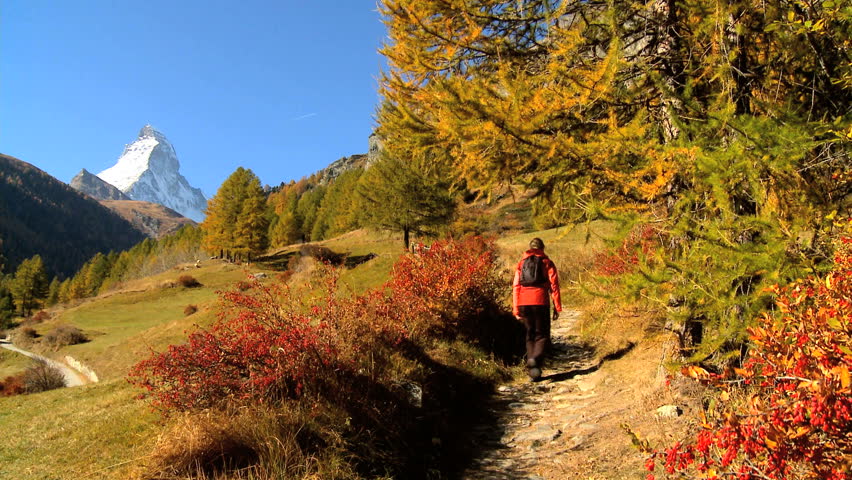 Fall in an alpine meadow, Zermatt, with female hiker & the Matterhorn, motion jib