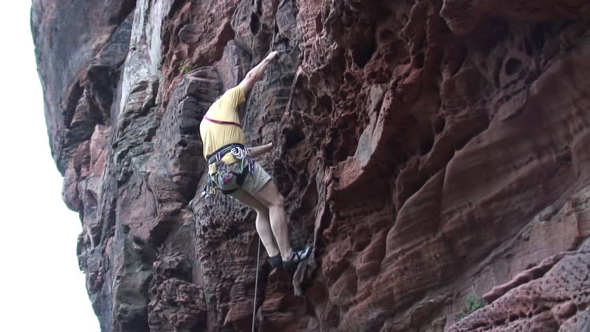 HD 1080i: Mountaineer climbing a rock.Tripod.