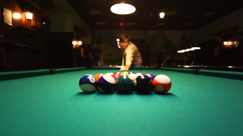 man in billiards shoots at balls 