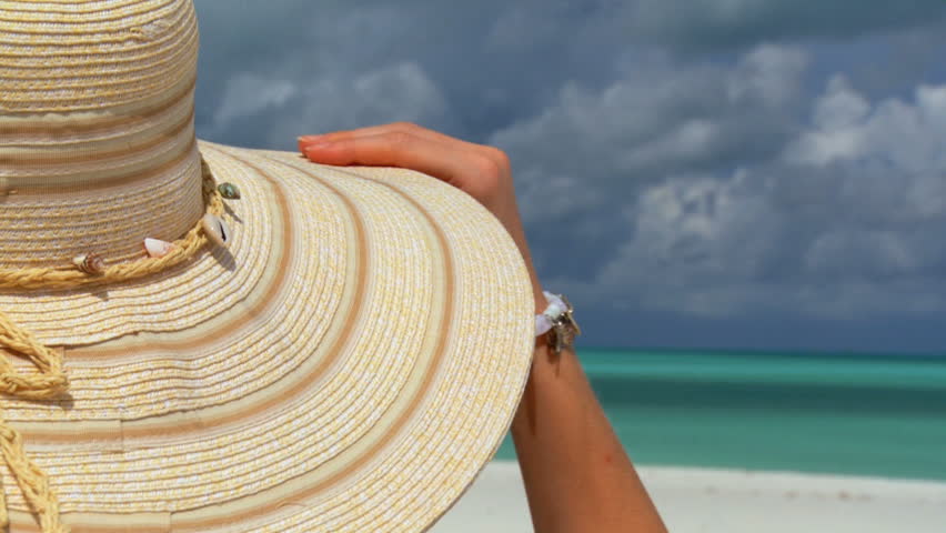 Elegant young female relaxing on white sandy beach looking at aquamarine waters 60 FPS