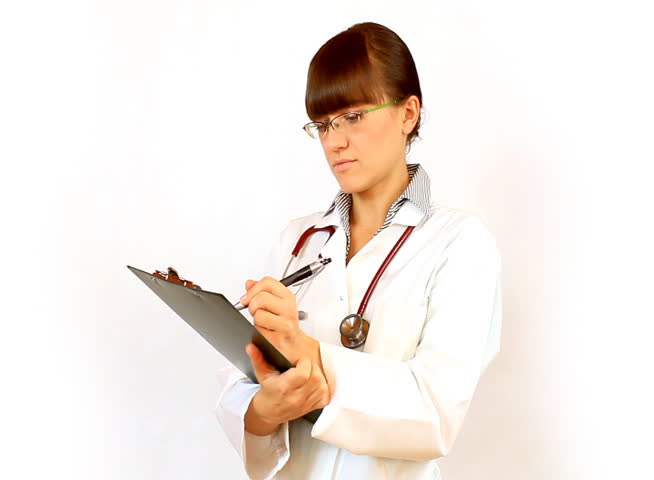 Female doctor in glasses recording something on notepad