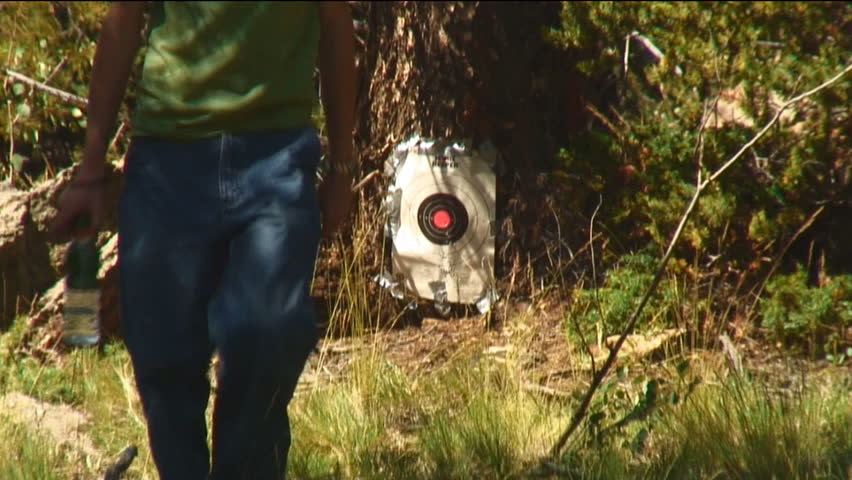 young man returns from checking target and shoots rifle
