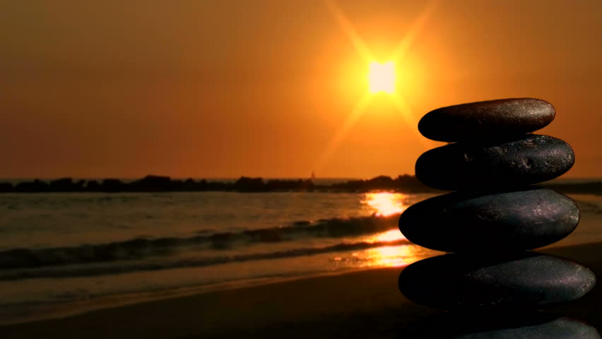 Stack of Zen rocks against ocean sunset