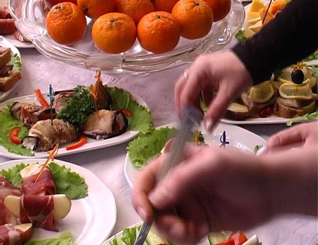 Table with food and human hand with plate