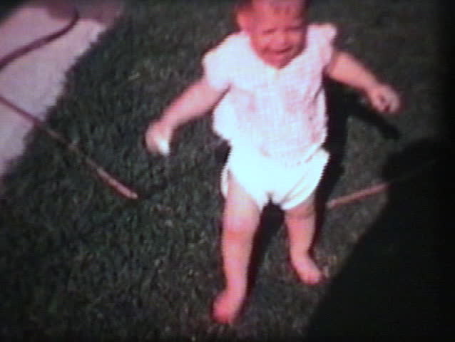 A little boy has a blast swimming in his wading pool while his little sister screams and cries and runs around the backyard. (Vintage 8mm film)
