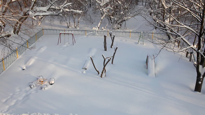 pan from playground to winter trees at sunny morning