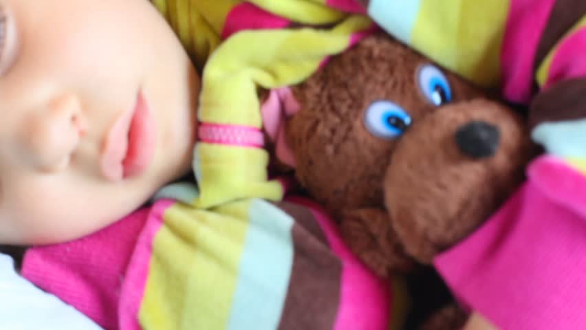 little girl with toy bear sleeping in compartment of railway carriage 