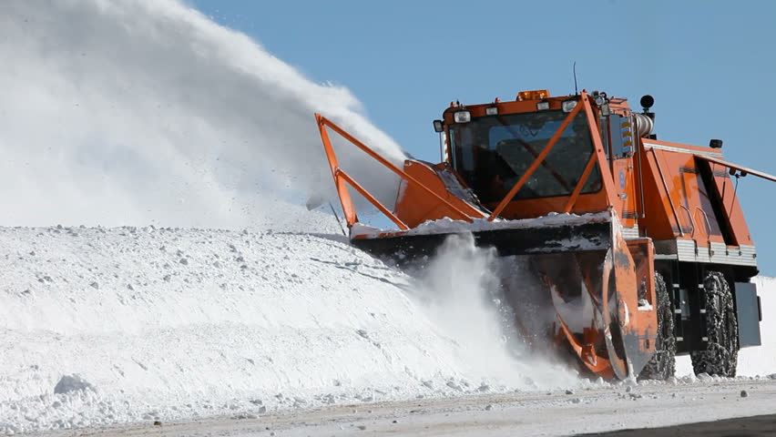 Snow blower removing snow from mountain road. Large vehicle with spinning blades throws ice and snow off the road. Deep and dangerous snow. Above Fairview, Utah. Don Despain of Rekindle Photo.