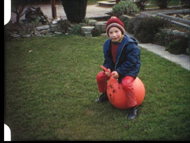 Boy hopping on ball (vintage 8 mm film)