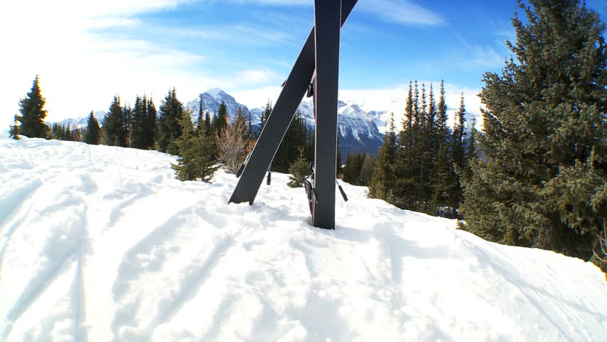 Crossed carver downhill skis standing in fresh clean snow in snowy mountain landscape