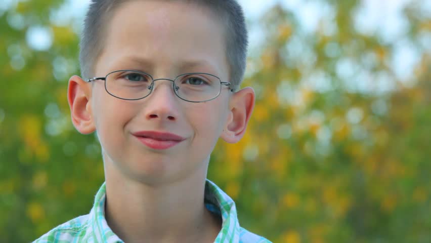 portrait of lop-eared bespectacled boy looking at camera outdoor 