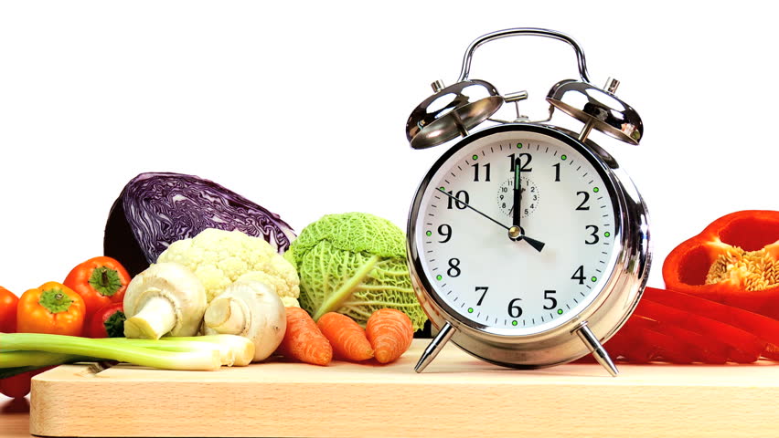 Clock hands reminding us to include delicious fresh vegetables as part of a daily modern healthy lifestyle diet