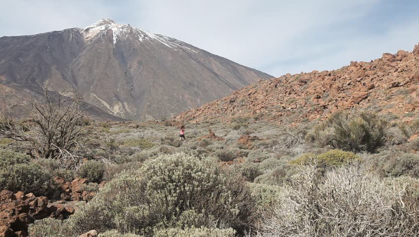 Running woman outdoors. Female trail runner jogging in the wild dessert nature on the Volcano Teide on Tenerife, the Canary Islands. 