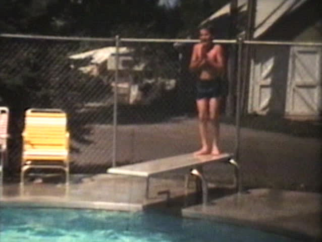 Three siblings have fun swimming in the pool and jumping off the diving board in the middle of a hot summer.